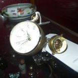 A replica Omega bullseye desk clock with Roman numeral dial and a similar