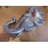 A pair of silvered elephant mask wall plaques
