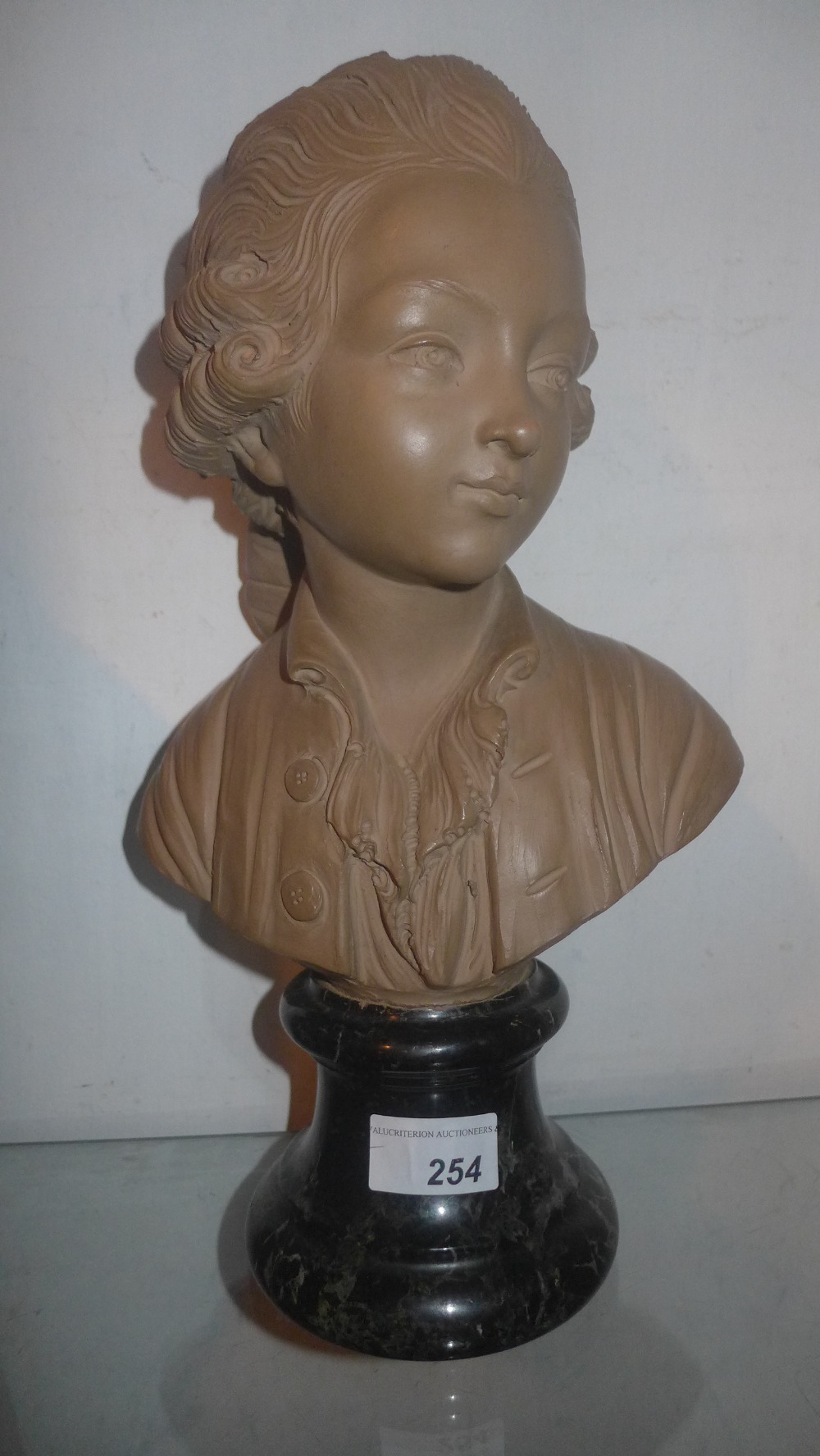 A terracotta bust of a classical composer on marble base