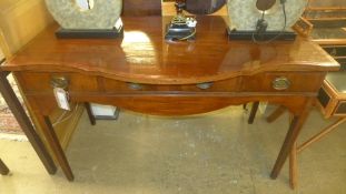 A George III mahogany serving table the shaped crossbanded top above three frieze drawers on square