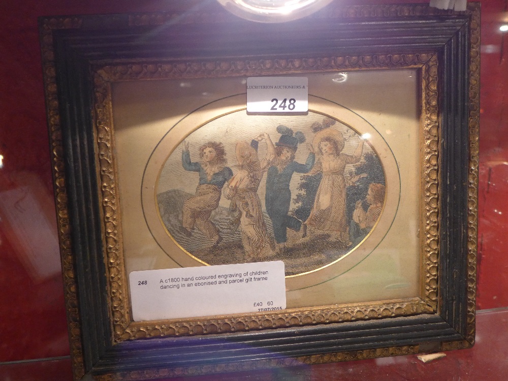 A c1800 hand coloured engraving of children dancing in an ebonised and parcel gilt frame