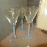 A set of four iridescent glass cocktail glasses on blue satin glass stems