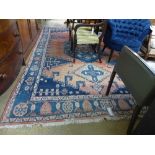 A Persian style carpet with medallion on blue and rust field within single border