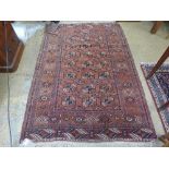 A Persian style rug with red ground and geometric border