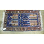 A Persian style carpet with blue and orange design in geometric border