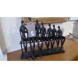 A Giacometti style model of figures seated in a row