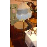 A carved hard wood standard lamp with blue tassle shade raised on hoof supports