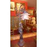 An Art Nouveau style table lamp in the form of a young lady with a pink frosted glass shade