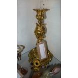 A Continental ormolu candlestick of having ornate floral detail in relief on a pierced scrolling