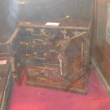 An early C20th Japanese black lacquered table top cabinet heightened in gilt and with fitted