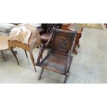 A Victorian carved oak Glastonbury chair with panel back and seat on frame supports