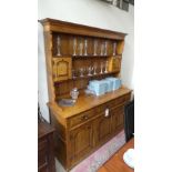 An oak dresser with open shelves over three drawers and panel doors on bracket feet 
H 185 cm x W