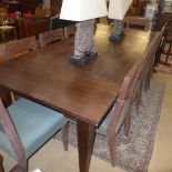 A large hardwood dining table having plank top on square tapering supports