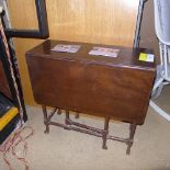 An Edwardian drop leaf table on pad feet