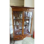 A mahogany and satinwood inlaid display cabinet having glazed doors enclosing shelves above two