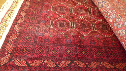 A fine North east Persian Turkoman rug 195 cm x 135 cm repeating gul motifs on a rouge field within