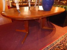 A Danish design teak extending dining table with two extra leaves on quadruped supports