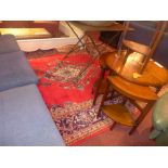 A large Persian carpet the red field decorated with floral motifs in a dark blue broad border