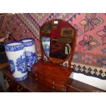 A Victorian mahogany swing frame toilet mirror fitted three drawers and having shield shaped plate