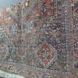 A hand knotted Persian rug the terracotta ground with stylised motifs