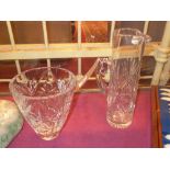 A tall cut glass pitcher and a similar v