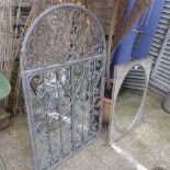 A wrought iron gated garden mirror