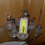 A silver topped and cut glass perfume bottle and a collection of similar