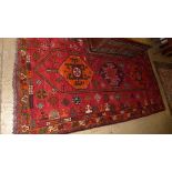 A fine Handwoven Persian Shiraz Quasgai carpet the madder field with central triple hexagonal motif