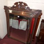 A Continental carved oak wall mirror with rectangular bevelled plate in a cushion border with