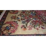A Persian rug, having ivory field with central stylised bouquet of flowers within vase enclosed by