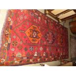A fine Handwoven Persian Shiraz Quasgai carpet the madder field with central triple hexagonal
