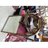 A pair of oval bevelled wall mirrors in ebonised frames