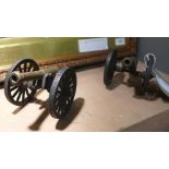 A pair of model cannons with brass barrels upon iron frame and wheels (2).