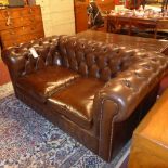 A Chesterfield two seater sofa upholstered in brown buttoned leather