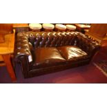 A Chesterfield three seater sofa upholstered in brown buttoned leather