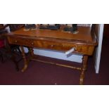 A Victorian walnut writing table with tooled leather top above drawers on stretchered supports