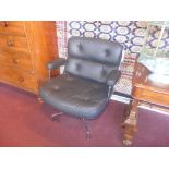 A contemporary designer executive desk chair upholstered in buttoned black leather on chrome