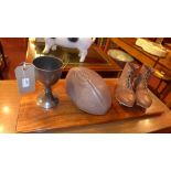 An arranged display of bygone footballing equipment and a similar of rugby interest on mahogany