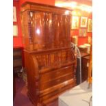 A Biedermeier flame mahogany cylindrical spoon cupboard having panel doors enclosing good fitted