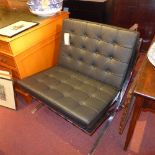 A Barcelona style chair upholstered in buttoned black leather on chromed supports and the matching