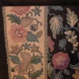 An Aubusson wall hanging with floral designs on a black field surrounded by an ivory floral field