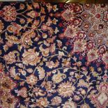 A Keshan style carpet with a central medallion on a midnight blue field decorated with palmettes