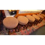 A set of six oak bar stools upholstered in check fabric raised on stretchered supports