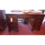 A mahogany desk the leather lined top above arrangement of drawers on plinth base