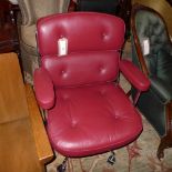 A contemporary designer executive's office chair upholstered in burgundy leather on chromed supports