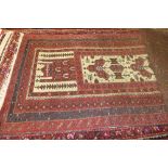 A hand knitted Lancassion rug the red fields with stylized decoration
