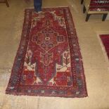 A hand knotted Belouch rug the brown fields with stylised decoration and a hand knotted Humedan