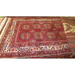 A fine north east Persian Turkoman rug 205cmx110cm repeating elephant foot motifs on a rouge field