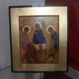 An Eastern icon depicting the Holy Trinity in a gilded frame