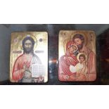 A pair of Orthadox icons, one depicting Jesus, the other the Holy Family, both having a gilded